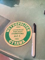 Front view of round cloth patch beside marker for scale