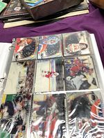 Sleeved hockey cards in nine-pocket page showing goalies and game action