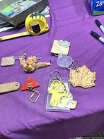 Overview of all eight keychains on purple surface