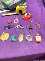Group shot of all 11 keychains on purple surface