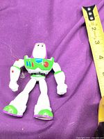 Front view of Buzz Lightyear figure with ruler for scale