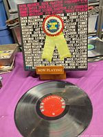 Front cover showing artist list and rosette, record on table