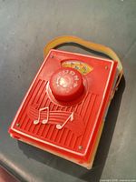 Front view showing red plastic face, TURN knob, musical notes
