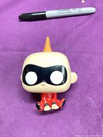 Front view of Funko Pop Jack-Jack figure showing mask, eyes, hair tuft and red suit