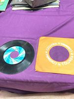 7" vinyl record and orange Columbia sleeve on table