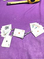 Full view of charm cluster showing multiple mini playing cards linked by metal chain