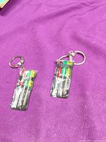 two keychain screwdriver sets in pouches on purple cloth