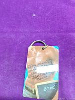 Front view of laminated cardboard keychain showing graphic and attached metal ring