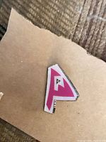 Front view of triangular pink and white Pokemon enamel pin