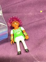 Front view of Playmobil figure with headdress and cuffs on purple background