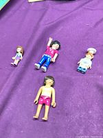 Four toy figures on purple surface