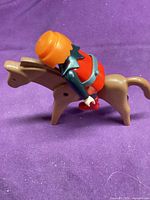 Side view of knight seated on tan horse