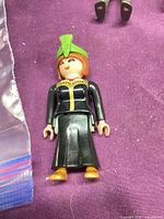 Front view of Playmobil figure lying flat showing outfit, hat, and overall condition
