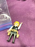 Front view of Playmobil figure showing star emblem, tool belt, hairpiece