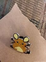 Front view of enamel pin showing character design and colors