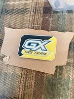 Front of rectangular GX Tag Team enamel pin displaying logo and colors