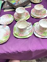 Multiple tea trios showing cups on saucers with matching plates