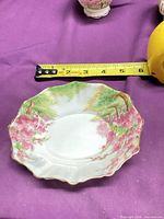 Top view of scalloped bowl showing Blossom Time pattern and measuring tape indicating size