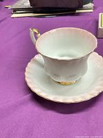 Tea cup on saucer showing pink rim and gold trim