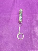 Full view of whistle keychain showing chain and key ring