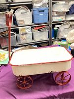 full view of white and red metal wagon with handle and wheels