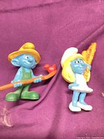 Front view of both Smurf figurines showing attire and accessories