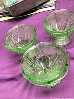 Three green etched glass footed sherbet dishes viewed from top