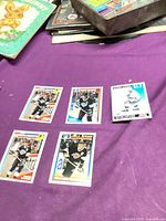 Five Wayne Gretzky cards displayed on purple cloth showing fronts