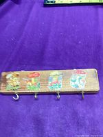 Front view showing wood rack, four hooks, mushroom decals