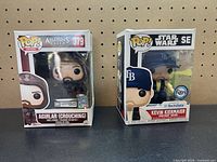 Front view of both boxed figures showing character names and exclusivity labels