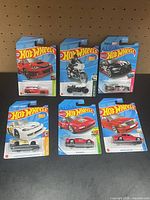 All six carded Hot Wheels vehicles laid out front view