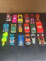 All 18 die-cast cars arranged in three rows on black surface