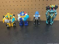 Group shot of all four figures standing side by side