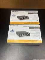 Front view of two sealed Netgear GS305 switch boxes
