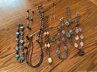 Full set of nine necklaces laid out to show variety in colour, bead style and length