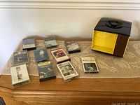 Overview of nine cassette tapes and storage carousel on table