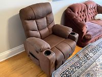 Front angled view of brown fabric power lift recliner chair next to sofa