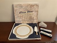 boxed set showing platter, cake server, napkin holder, spreader boxes