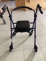Front view of blue Drive Medical rollator walker showing four wheels, padded seat and storage bag