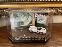 Display case with car and backdrop