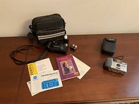 Lot overview showing both cameras, bags, manuals, batteries, cleaner and strap