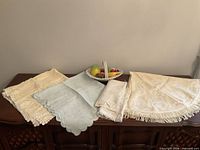 All linens folded on table with ceramic fruit basket