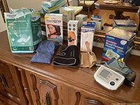 All items displayed on dresser including monitor, braces, heat pads, underpads