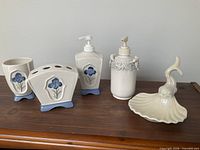 Five ceramic bathroom accessories grouped on surface