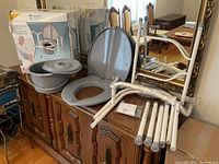 Full lot: box, gray seat and bucket, white frame parts on dresser