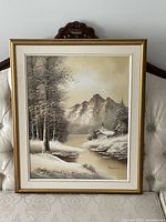 Full view of framed painting on sofa showing winter scene, frame and mat