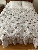 Full view of bedspread on queen bed with shams showing embroidery pattern