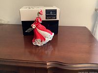 Front view of figurine standing before original box