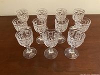 Full set of 11 cut crystal cordial glasses displayed upright