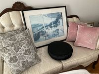 Overall lot on settee showing framed print, grey pillows, pink pillows, black cushion
